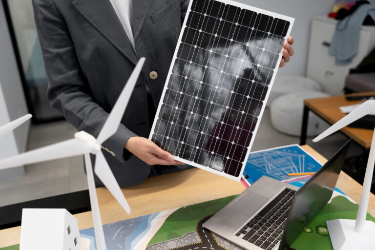Ein Mann hält zur Veranschaulichung ein Modell von einem Solarpanel