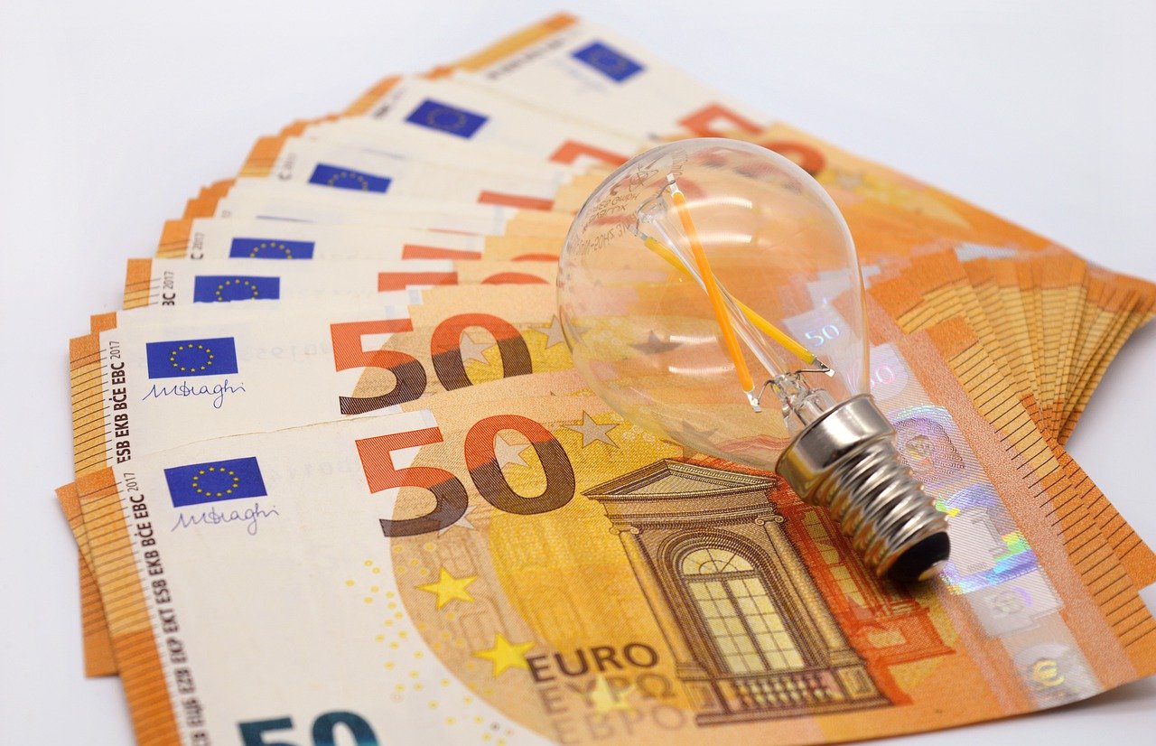 Energiepreise - 50 Euro Scheine liegen aufgefächert, Glühbirne liegt darauf