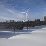 Erneuerbare Energie. Photovoltaikanlagen und ein Windrad.