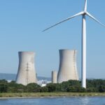 Atomkraftwerk neben einem Windrad